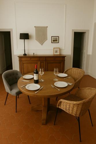 - une table en bois avec des chaises et une bouteille de vin dans l'établissement ElégantT2 à deux pas du Cours Mirabeau, à Aix-en-Provence