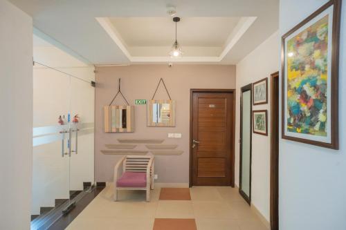 a hallway with a door and a chair at Ahuja Residency Parklane in Gurgaon