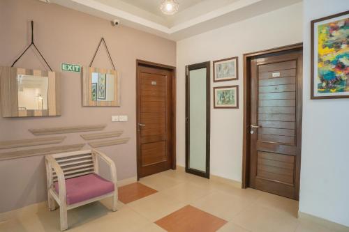 a hallway with wooden doors and a purple chair at Ahuja Residency Parklane in Gurgaon