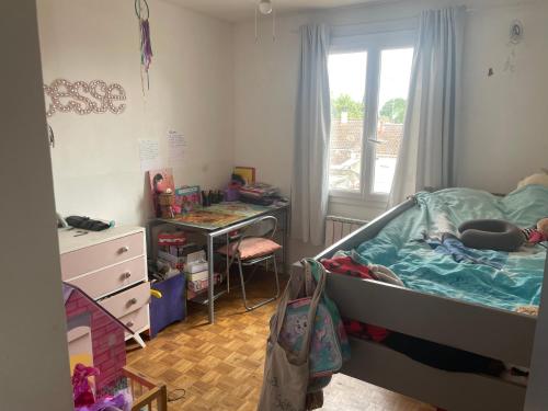 une chambre avec un lit, un bureau et une fenêtre dans l'établissement Maison laurier, à Saint-Just