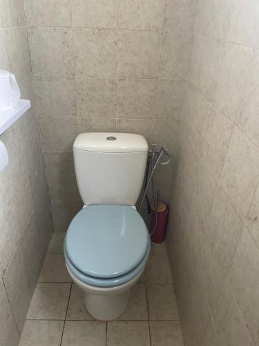 La salle de bains est pourvue de toilettes avec un siège bleu. dans l'établissement Maison laurier, à Saint-Just