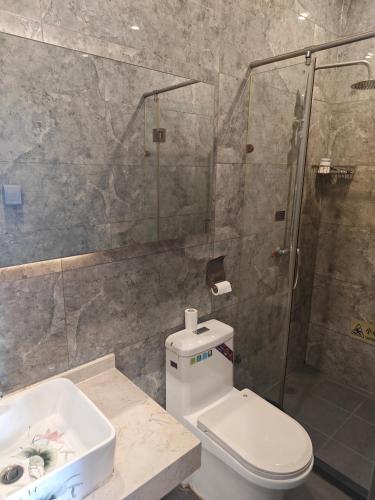 a bathroom with a shower and a toilet and a sink at Beijing Huiqing Garden Bussiness Hotel in Beijing