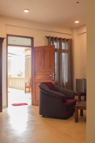 a living room with a couch and a sliding glass door at Hotel Coconut Bar Sea Lodge in Beruwala
