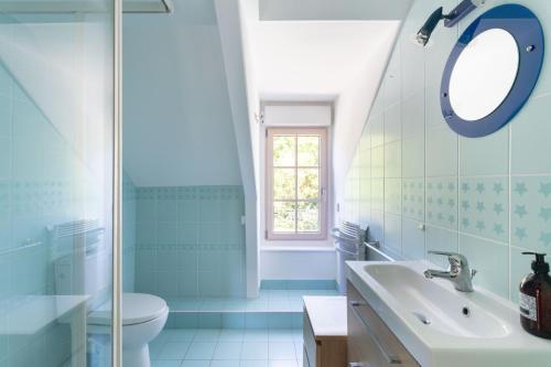 une salle de bain avec un lavabo et un miroir dans l'établissement Ker Aventin - Jolie maison classée 3 étoiles, à Pléneuf-Val-André