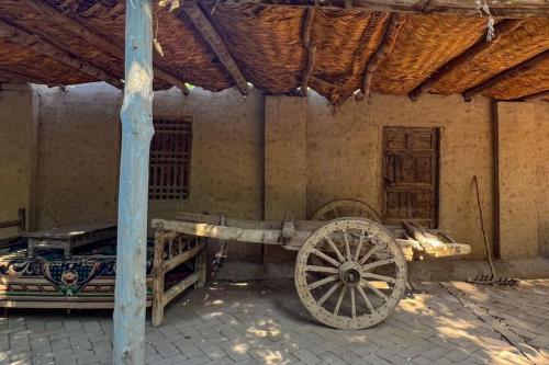 a wooden cart parked in front of a building at turpan Ah Fanti Village in Turfan