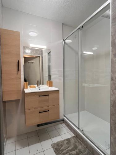 CourcouronnesにあるEden suiteのガラスのシャワーと洗面台を備えたバスルーム