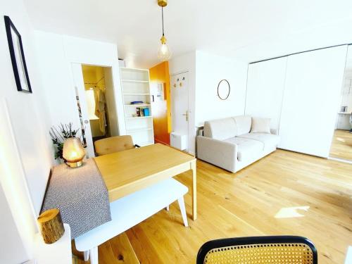 un salon avec une table et un canapé dans l'établissement Au calme sur jardin tres bel appartement lumineux, à Paris
