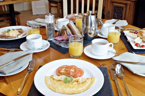 a table with a plate of food with tomatoes on it at Bronte Guest House in York