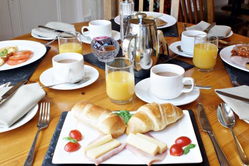 a table with plates of bread and cups of orange juice at Bronte Guest House in York
