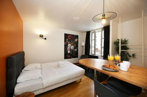 une chambre avec un lit et une table en bois dans l'établissement 302 sejournez dans un studio de charme paris 5, à Paris