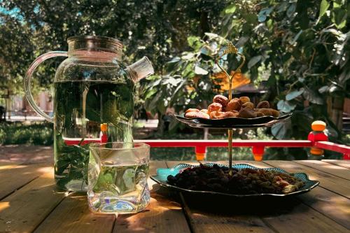 a table with a glass jar and a plate of fruit at turpan Ah Fanti Village in Turfan