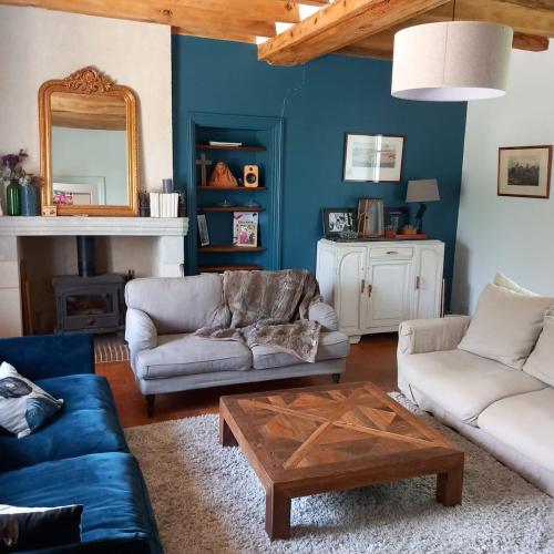 un salon avec un canapé et une table dans l'établissement Maison de charme à la campagne, à Juvardeil