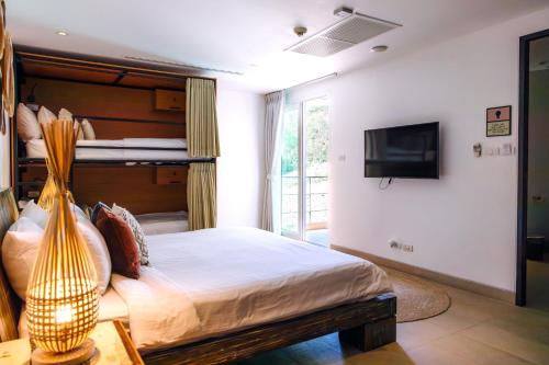 a bedroom with a bed and a tv and a bed sidx sidx sidx at Selina Serenity Rawai Phuket in Rawai Beach