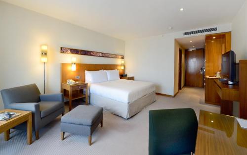 a hotel room with a bed and a desk and chair at Canary Riverside Plaza Hotel in London