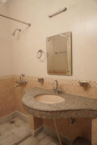 a bathroom with a sink and a mirror at Atreya Boutique Cottage Serene Villa Near Ram Jhula in Rishīkesh