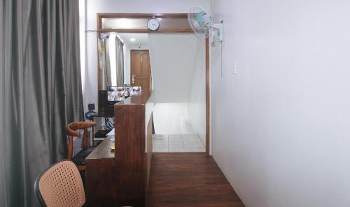 a hallway with a desk and a clock on the wall at GREN PLACE near Baclaran Airport Road by RedDoorz in Manila
