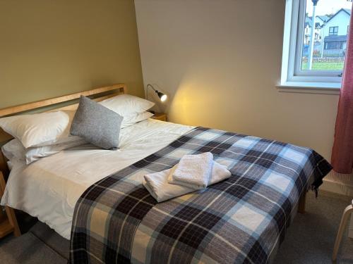a bedroom with a bed with two pillows on it at Gorgeous Dornoch apartment in Dornoch