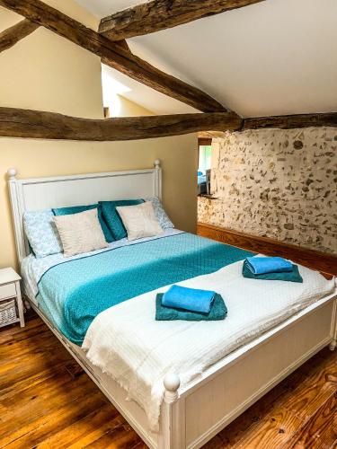 une chambre avec un lit avec des oreillers bleus dessus dans l'établissement Le Petit Nid, à Romagne