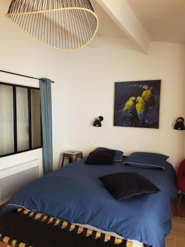 - une chambre dotée d'un lit bleu et d'une peinture murale dans l'établissement Maison près de la plage à la Guérinière, à La Guérinière