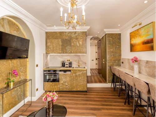 une cuisine avec un bar et un lustre dans l'établissement Merveil - Luxury Suite - Louvre - Rousseau, à Paris