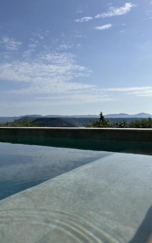 une piscine avec vue sur l'eau dans l'établissement LA GRANGE - Maison de vacances - Entre lac et montagne, à Liausson