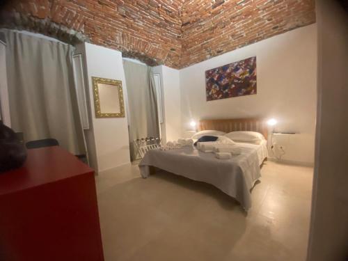 a bedroom with a bed and a brick wall at Torrione Stella Rooms in Sarzana