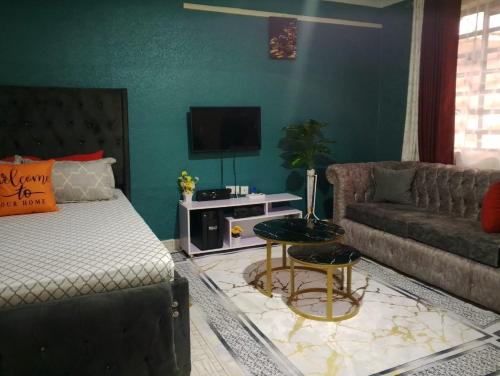 a living room with a bed and a couch at Joo's studio in donholm along spine road in Nairobi