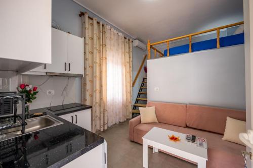 une petite cuisine et un salon avec un canapé dans l'établissement Vila Basho, à Saranda