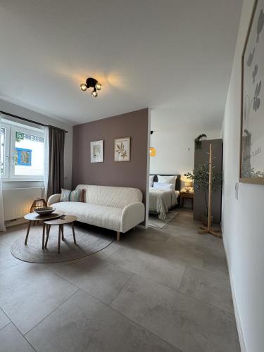 a living room with a couch and a table at FILDER quartett Apartmenthotel in Filderstadt