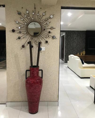 a red vase sitting in a room with a mirror at Escapade Lux Guesthouse in Gaborone