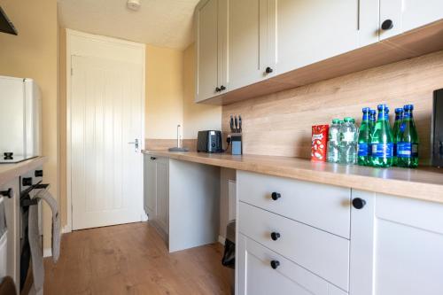 a kitchen with white cabinets and bottles on a counter at Finlow Place in Dundee