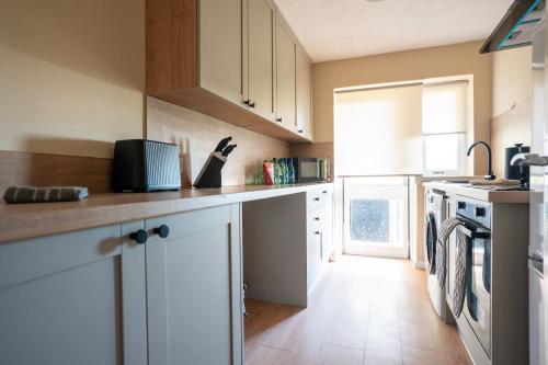 a kitchen with white cabinets and a wooden floor at Finlow Place in Dundee