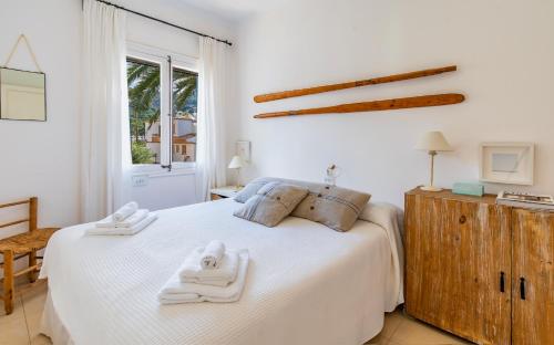 a bedroom with a white bed with towels on it at Casita Dragonera Sant Elm by Mallorca Infinity in Sant Elm