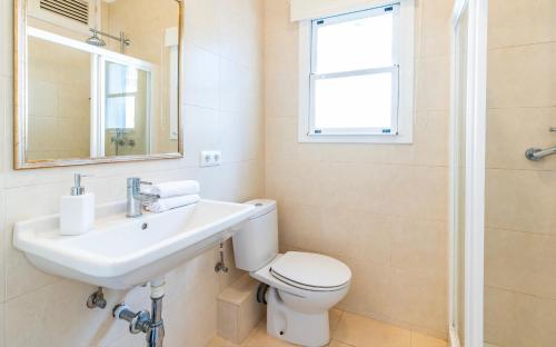 a bathroom with a toilet and a sink and a mirror at Casita Dragonera Sant Elm by Mallorca Infinity in Sant Elm