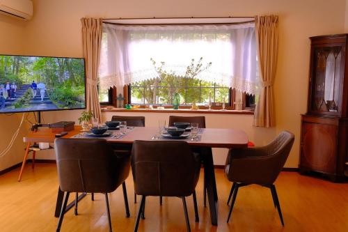 a dining room table with chairs and a large window at azabu living in Fukuoka