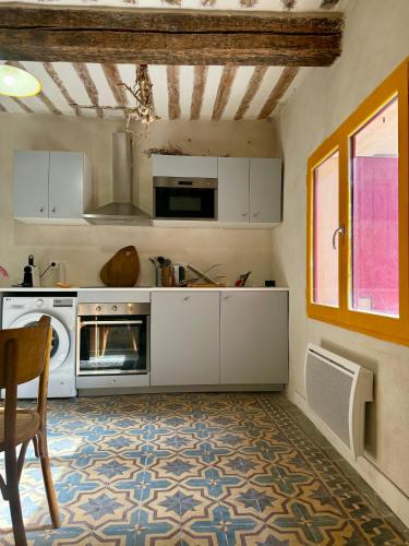 une cuisine avec des armoires blanches et une cuisinière dans l'établissement Le vieux Fournil, à Castillon-du-Gard