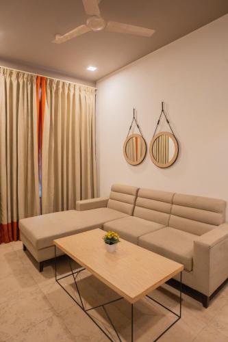 a living room with a couch and a table at Ahuja Residency Parklane in Gurgaon
