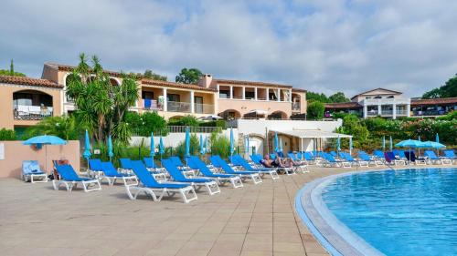 - une piscine dans un complexe avec des chaises longues bleues dans l'établissement Ambiance Méditerranée aux Parcs de Grimaud, à Grimaud