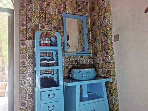 a bathroom with a blue cabinet and a mirror at turpan Ah Fanti Village in Turfan