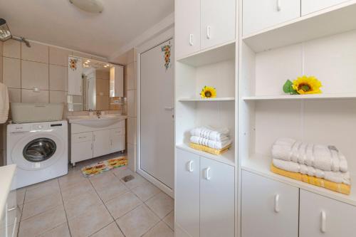 a white laundry room with a washer and dryer at Sunflower House with Jacuzzy and Sauna in Vitanje