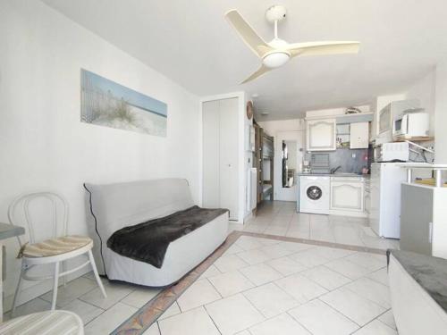 un salon avec un canapé et un ventilateur de plafond dans l'établissement Reflet du Sud - 4pers - Histoire de cles, au Cap d'Agde