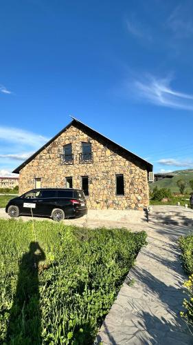 a car parked in front of a stone building at Jermuk garden in Jermuk