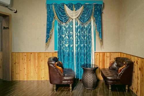 two leather chairs in a room with a window at turpan Ah Fanti Village in Turfan