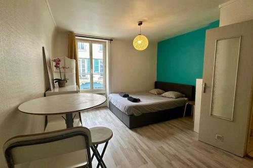 une petite pièce avec un lit et une table dans l'établissement Charming Studio in the heart of Fontainebleau, à Fontainebleau