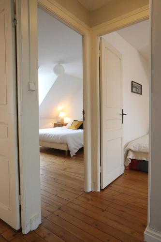 une porte ouverte sur une chambre avec un lit dans l'établissement Large house 80m from the port of Paimpol, à Paimpol