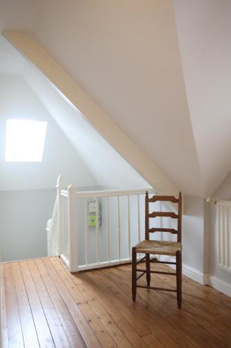 une chaise posée sur un plancher en bois dans un grenier dans l'établissement Large house 80m from the port of Paimpol, à Paimpol
