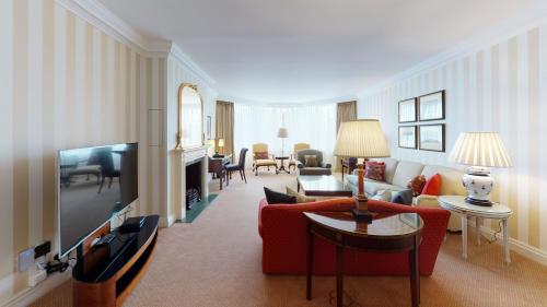 a living room with a red couch and a television at Cheval Thorney Court at Hyde Park in London