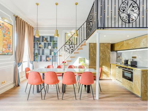 - une cuisine et une salle à manger avec une table et des chaises orange dans l'établissement Merveil - Luxury Suite - Opera - Septembre I, à Paris