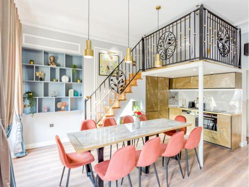 une salle à manger avec une table et des chaises et un escalier dans l'établissement Merveil - Luxury Suite - Opera - Septembre I, à Paris