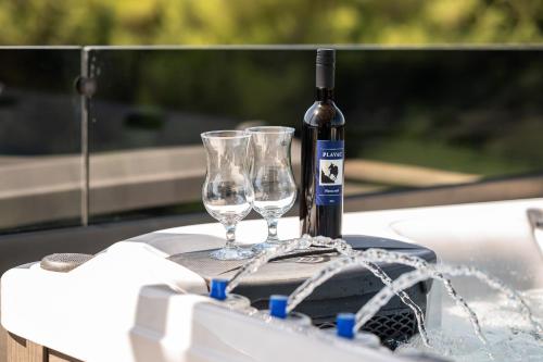 a bottle of wine and two wine glasses on a table at Penthouse FRANITA 50 meters from the beach in Kaštela